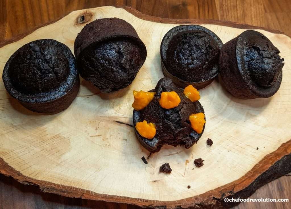 5 invitanti muffin all'acqua con cacao con pezzetti di zucca su un bellissimo tagliere di legno d'ulivo
