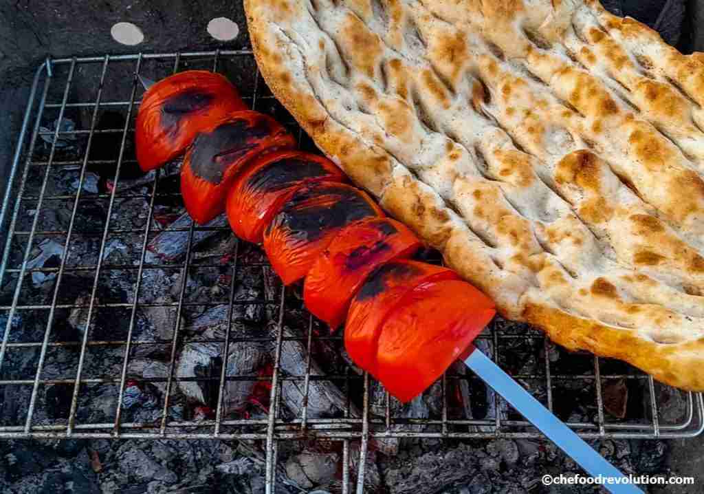 Delicious skewer of tomatoes and a Turkish flat bread put on the grill to cook