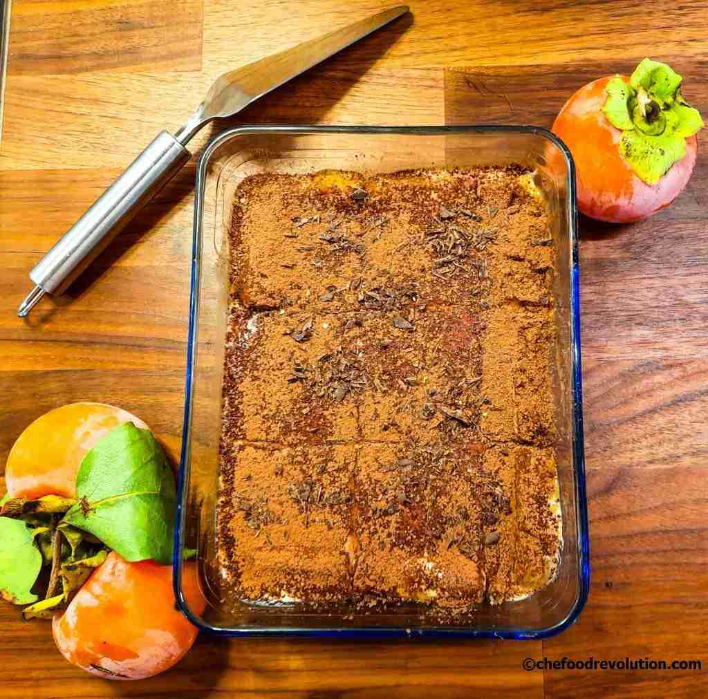 pirofila di vetro contenente un delizioso tiramisù di cachi con sopra scaglie di cioccolato