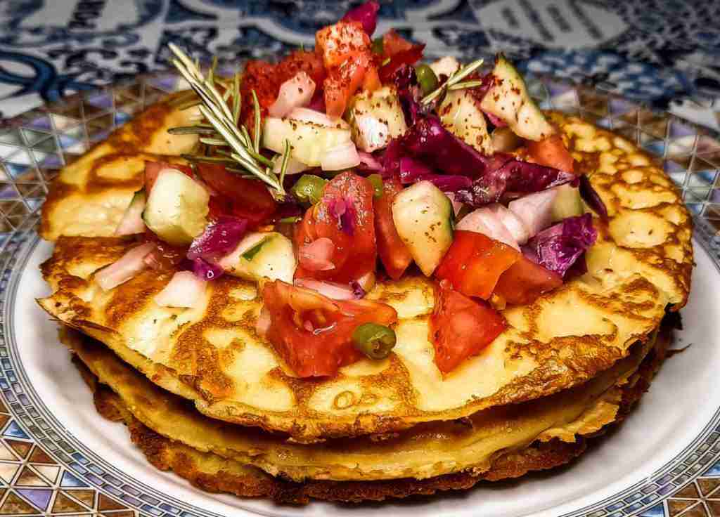 deliziose e colorate crepes senza uova con sopra pomodori, cetrioli e rosmarino