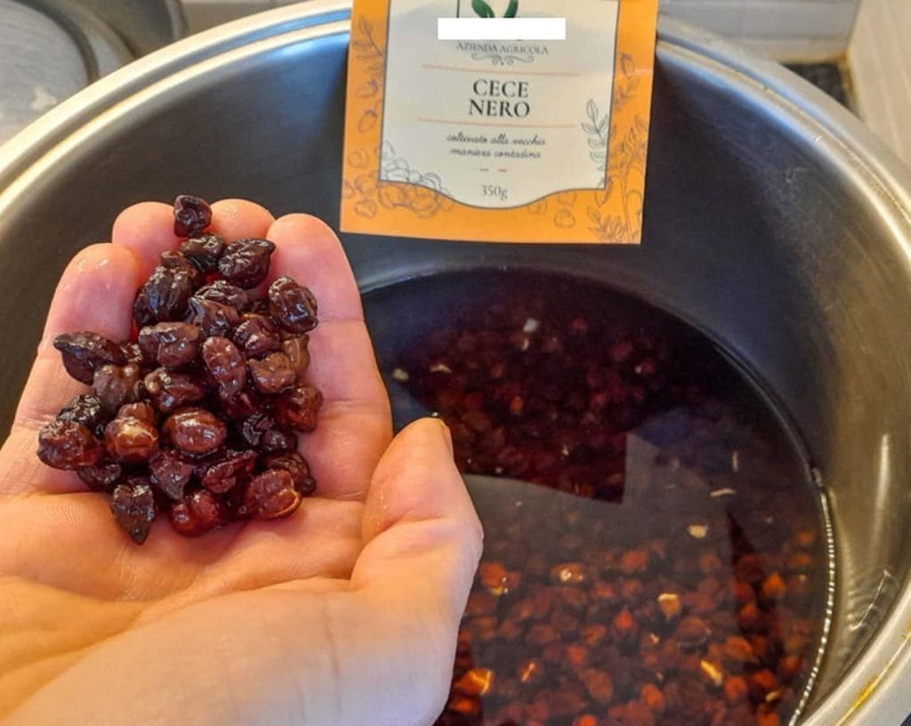 pentola con ceci neri in ammollo e manciata di ceci neri in una