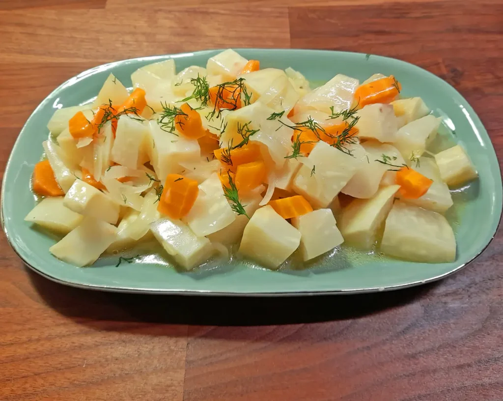 On a fancy plate a delicious sour and sweet celeriac side dish with quince, carrots and orange
