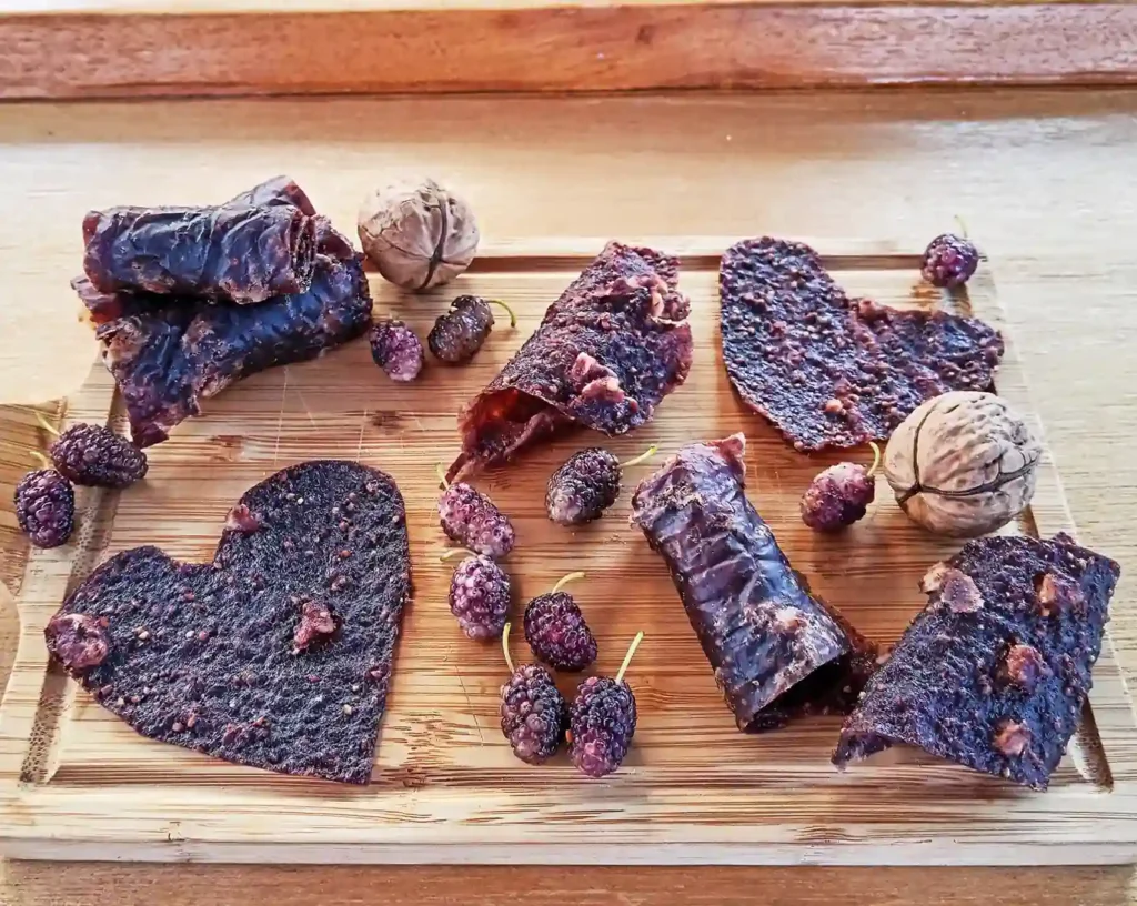 Deliziosa pelle di frutta preparata con i gelsi, tagliata in diverse forme servita su un tagliere di legno
